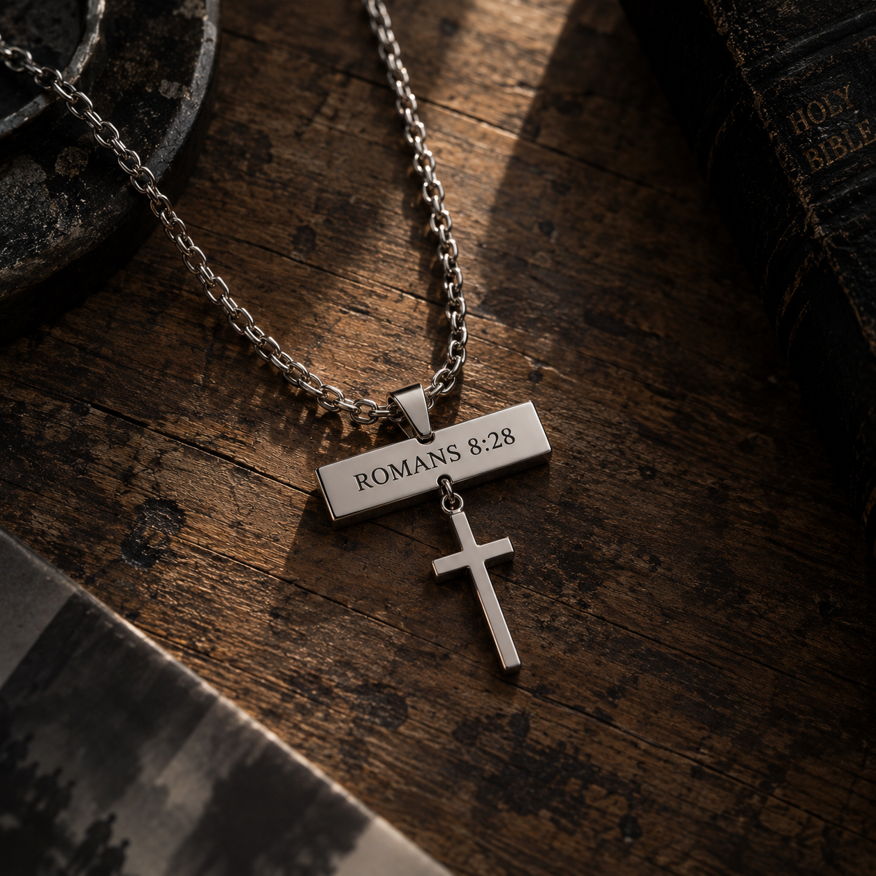 Engraved bar pendant resting on dark wood beside a Bible